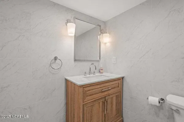 a bathroom with a sink a toilet and a mirror