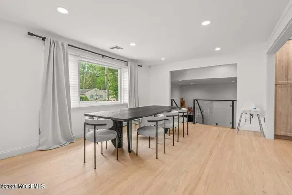 a dining hall with stainless steel appliances granite countertop a table chairs and a sink