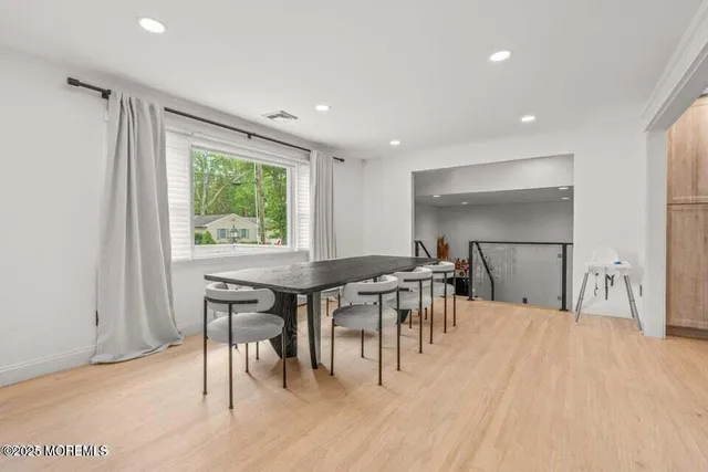 a dining hall with stainless steel appliances granite countertop a table chairs and a sink