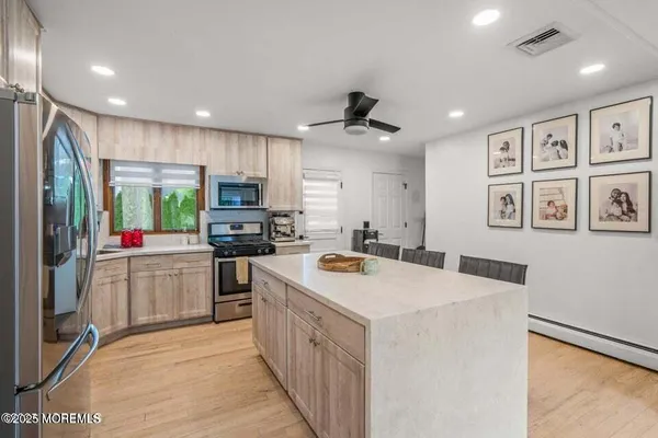 a kitchen that has a lot of cabinets a sink and appliances