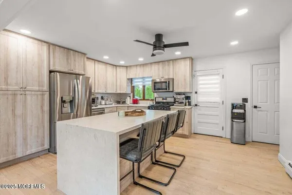a kitchen with refrigerator a stove a sink and a refrigerator with wooden floor