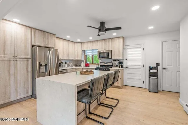 a kitchen with refrigerator a stove a sink and a refrigerator with wooden floor