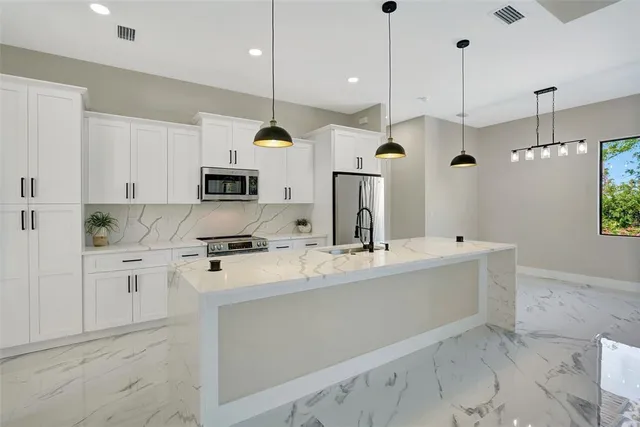 a kitchen with kitchen island a counter top space appliances and cabinets