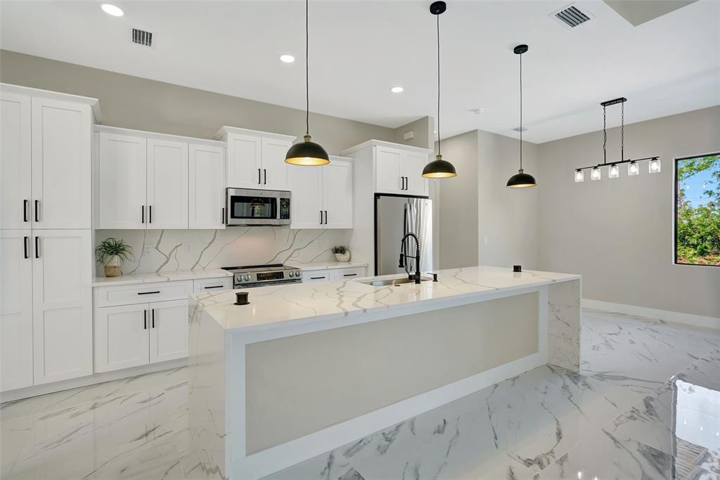 212 Fairway Road Rotonda West, FL 33947 - Photo 3 of 65 a kitchen with kitchen island a counter top space appliances and cabinets
