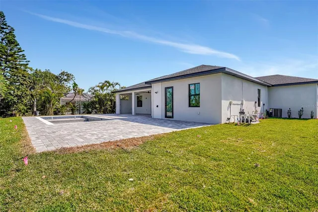 an aerial view of a house with a yard swimming pool and outdoor seating