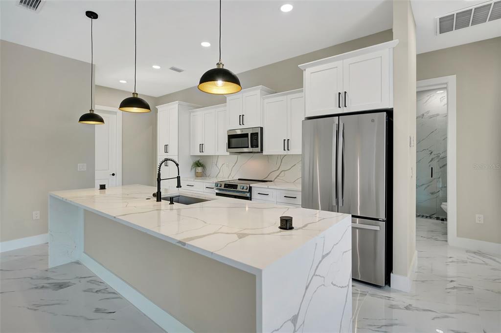 212 Fairway Road Rotonda West, FL 33947 - Photo 5 of 65 a kitchen with stainless steel appliances a refrigerator sink and microwave