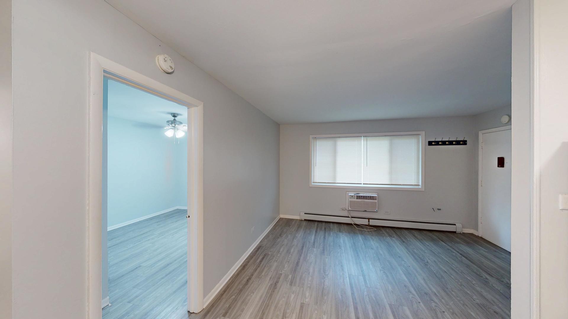 501 Chicago Road, Unit 11 Thornton, IL 60476 - Photo 2 of 8 an empty room with wooden floor and windows
