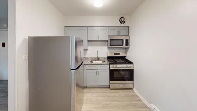 a kitchen with stainless steel appliances granite countertop a refrigerator and a stove