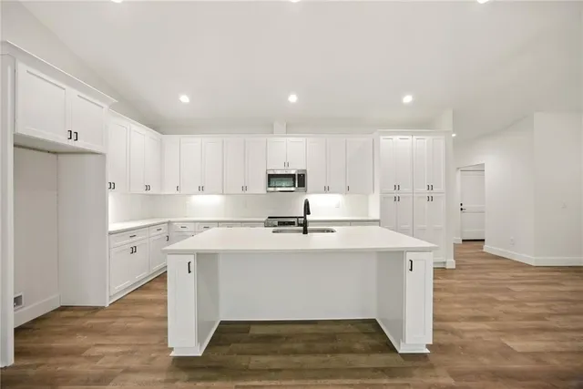 a view of kitchen with stainless steel appliances refrigerator sink and cabinets