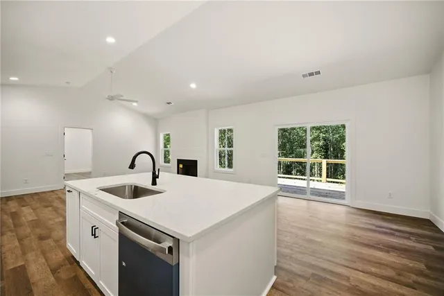 a kitchen that has a sink a stove and wooden floor