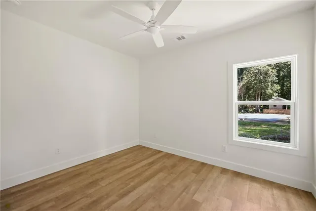 an empty room with a window and wooden floor