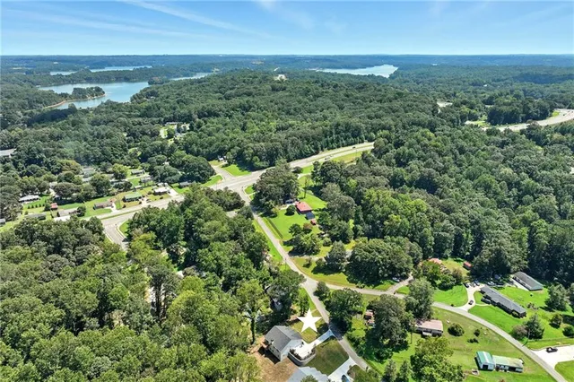an aerial view of a city with lots of residential buildings green landscape and ocean view