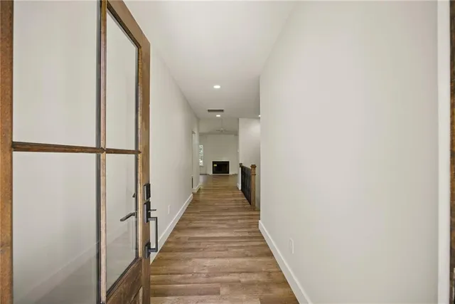 a view of a hallway with wooden floor and staircase