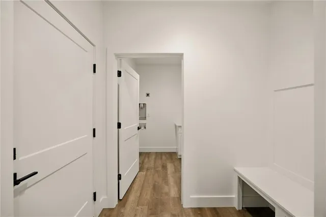 a view of a hallway with wooden floor and staircase