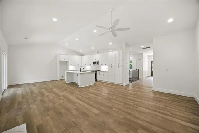 a view of an empty room with kitchen appliances and a window
