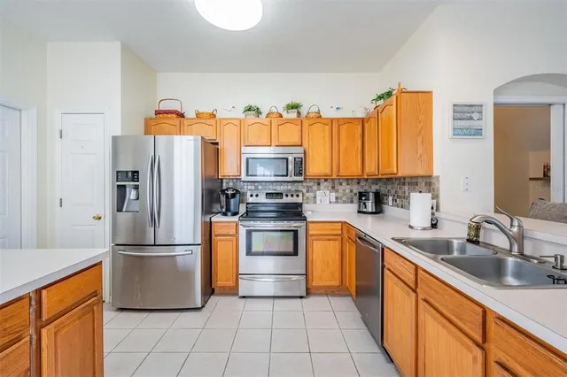 a kitchen with stainless steel appliances granite countertop a refrigerator and a sink