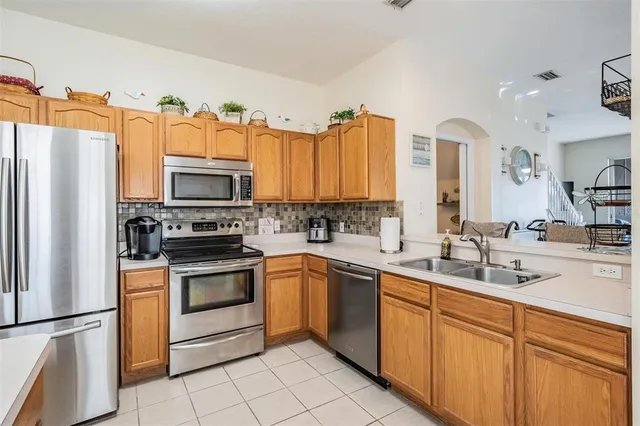 a kitchen with kitchen island granite countertop a sink stainless steel appliances and cabinets