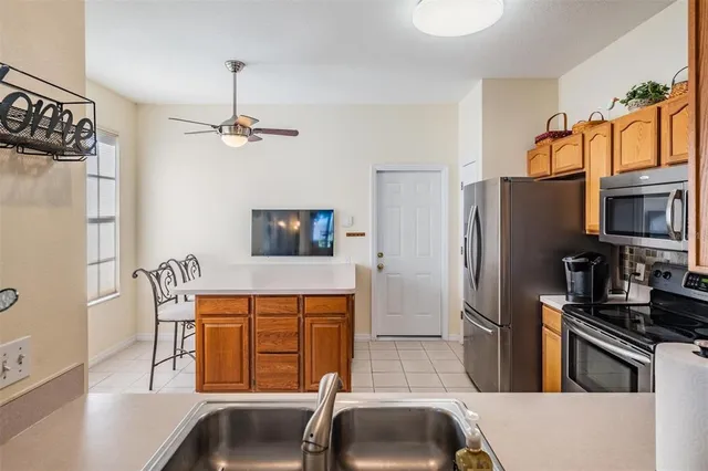a kitchen with stainless steel appliances a refrigerator a sink a stove and white cabinets