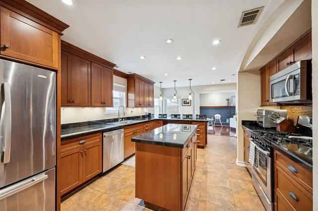a kitchen with stainless steel appliances granite countertop a stove refrigerator sink and cabinets