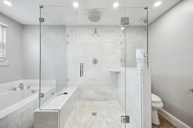 a bathroom with a bathtub shower sink vanity and toilet