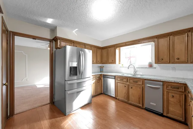 a kitchen with stainless steel appliances granite countertop a refrigerator and a sink