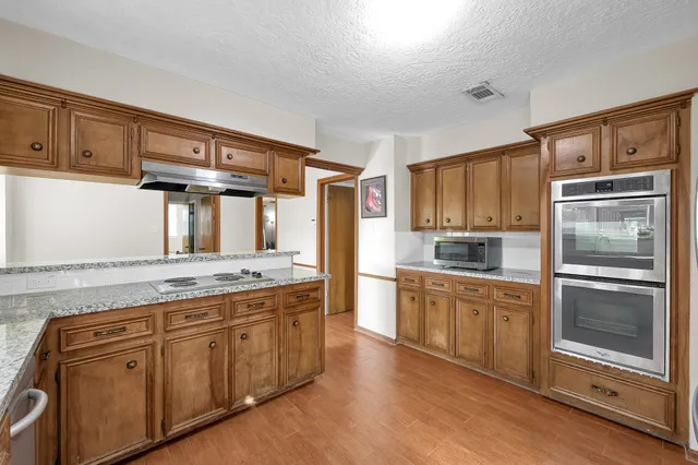 a kitchen with granite countertop stainless steel appliances and wooden cabinets