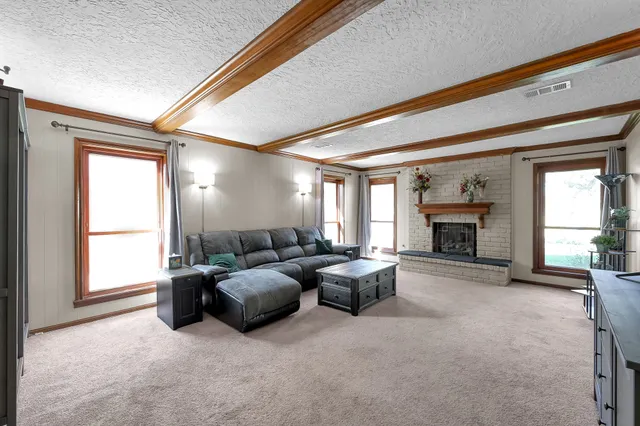 a living room with furniture large window and fireplace