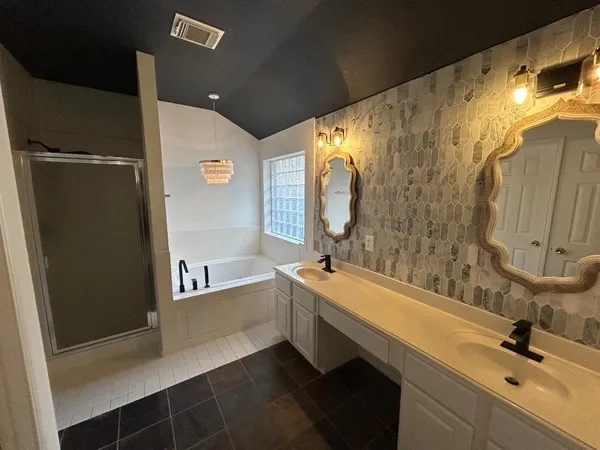 a bathroom with a double vanity sink a mirror and a bathtub