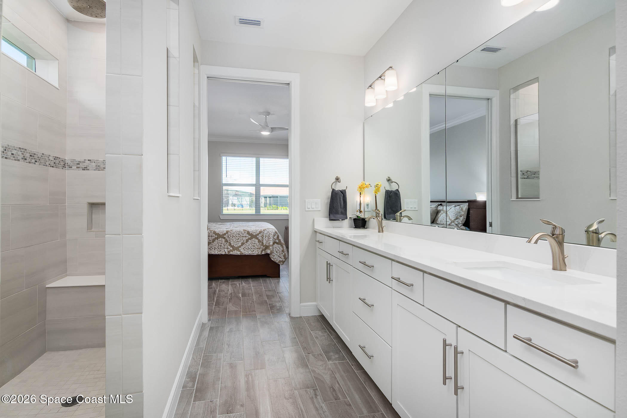 3032 Tidepool Place Melbourne, FL 32940 - Photo 20 of 67 a en suite bathroom with a double vanity sink a mirror and shower