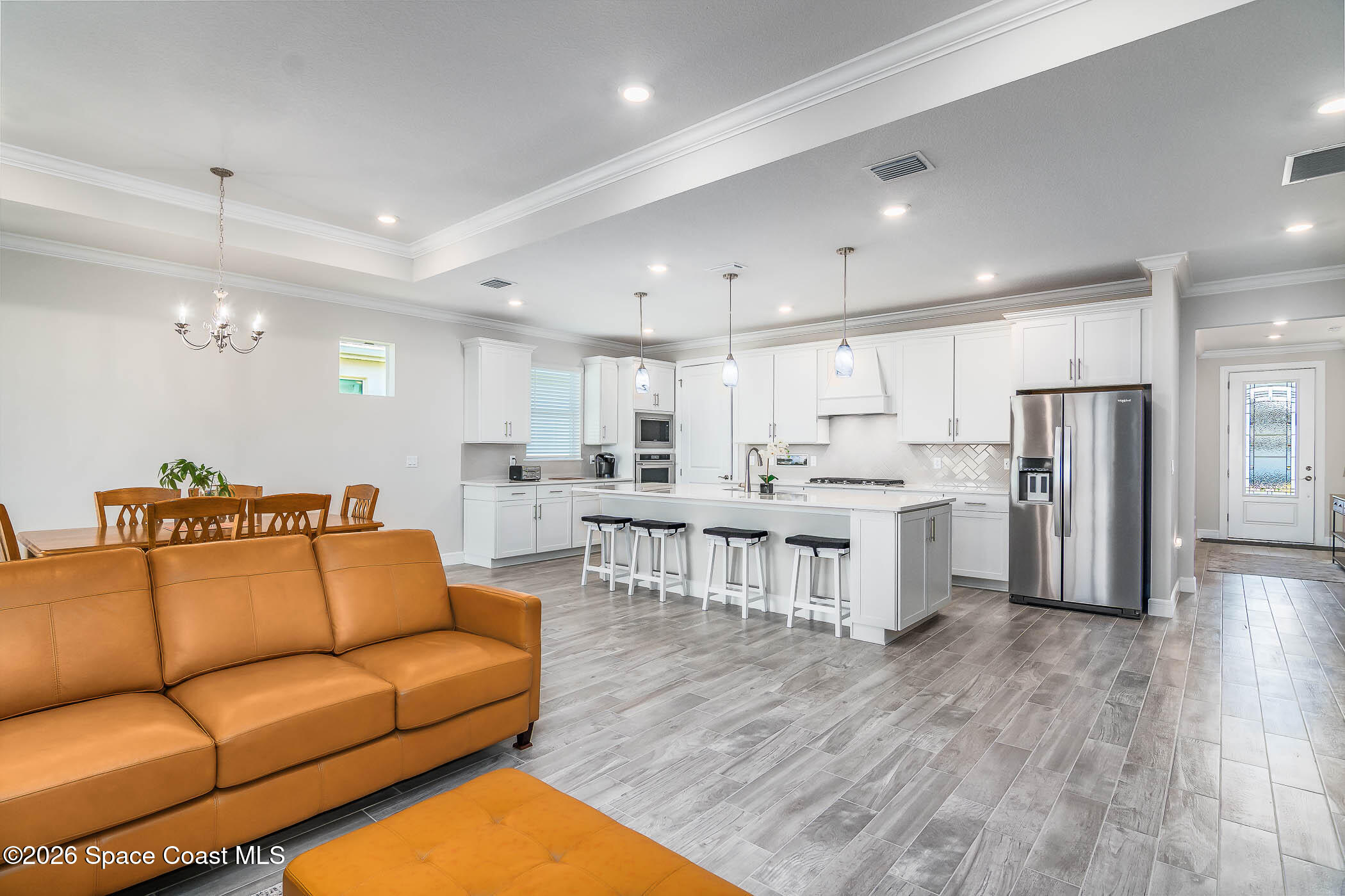 3032 Tidepool Place Melbourne, FL 32940 - Photo 44 of 67 a living room with stainless steel appliances kitchen island a refrigerator a stove a dining table and chairs