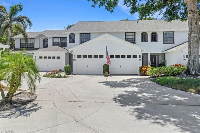 a view of a white house with a yard and plants