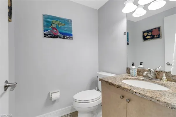 a bathroom with a granite countertop sink mirror and toilet