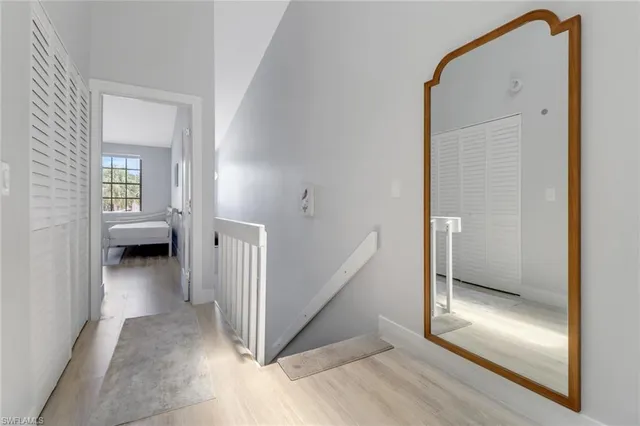 a view of a hallway with wooden floor and a living room