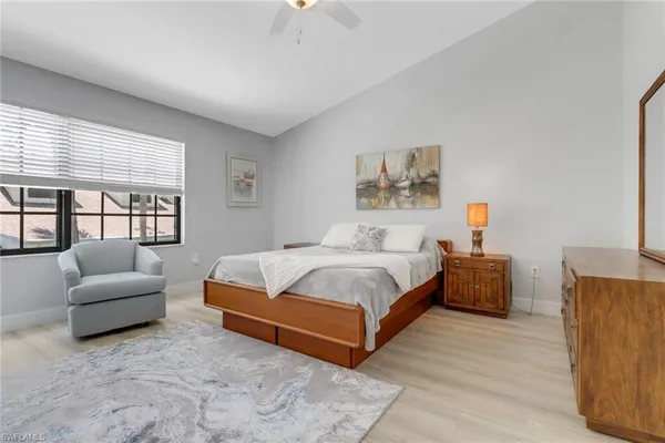 a spacious bedroom with a bed a couch and a large window