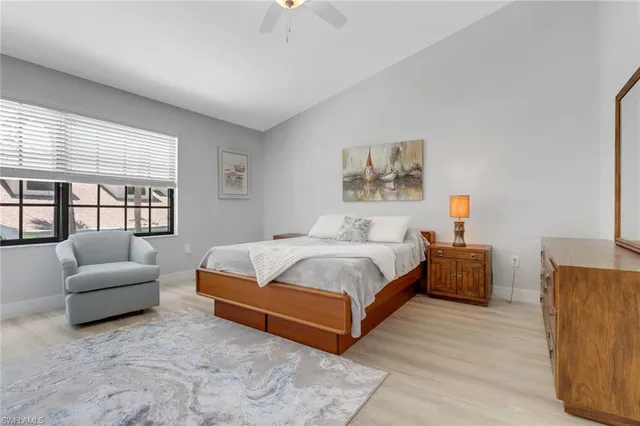 a spacious bedroom with a bed a couch and a large window