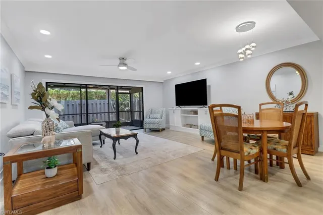 a living room with furniture a flat screen tv and a floor to ceiling window
