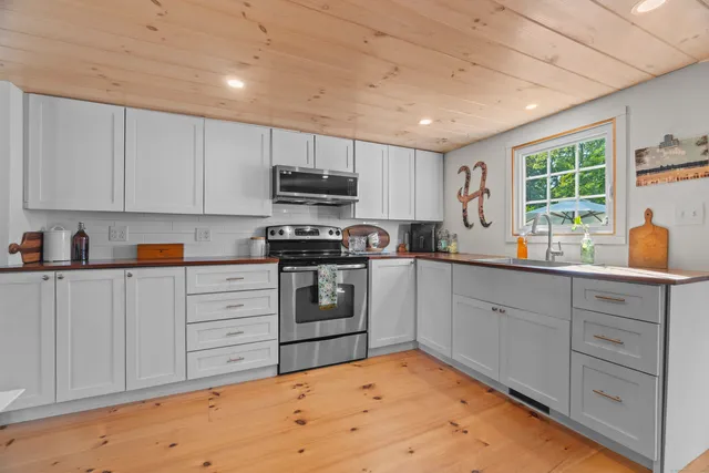 a kitchen with a sink window and cabinets