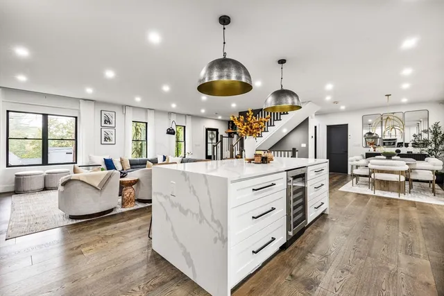 a kitchen with stainless steel appliances granite countertop a stove oven a dining table and chairs with wooden floor