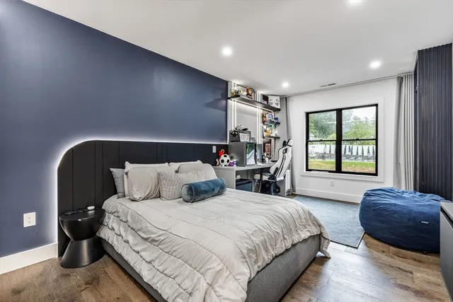 a large bedroom with a bed and a refrigerator