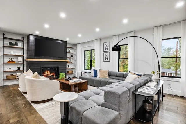 a living room with furniture a large window and a fireplace