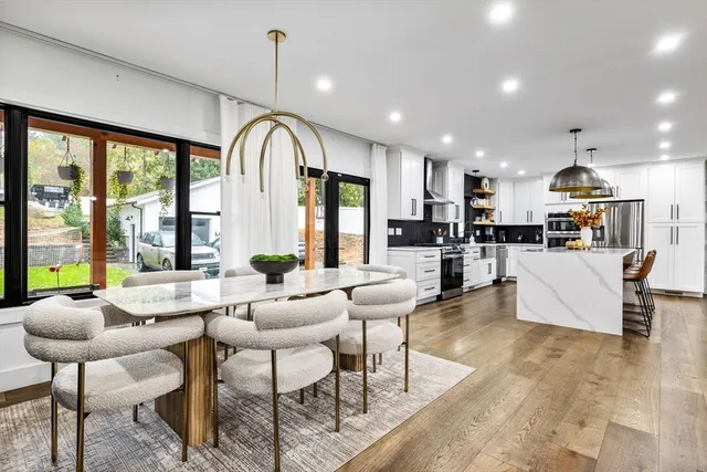 a living room with stainless steel appliances kitchen island granite countertop furniture and a large window