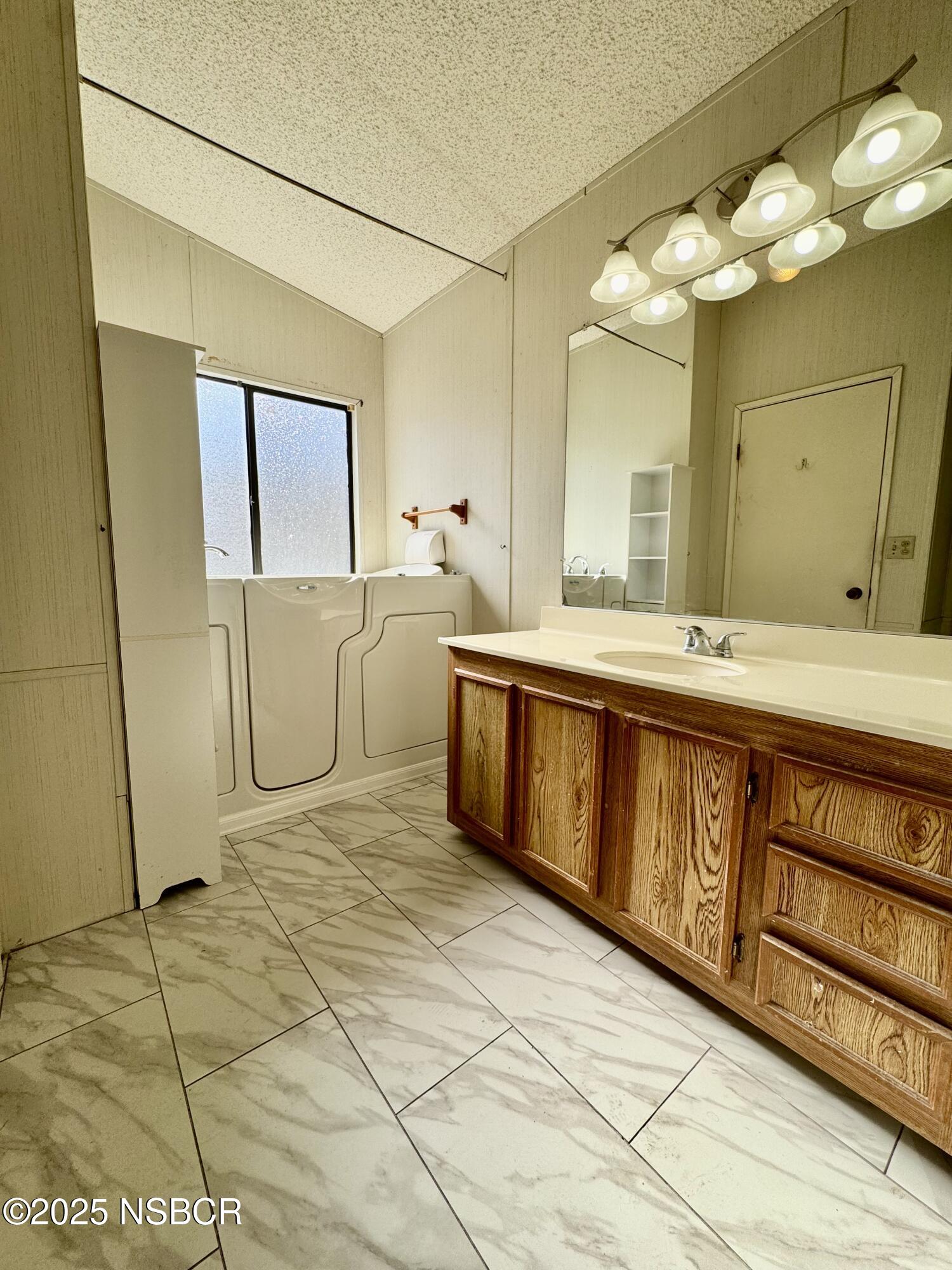 1317 V Street, Unit 58 Lompoc, CA 93436 - Photo 15 of 34 a spacious bathroom with a double vanity sink and a mirror