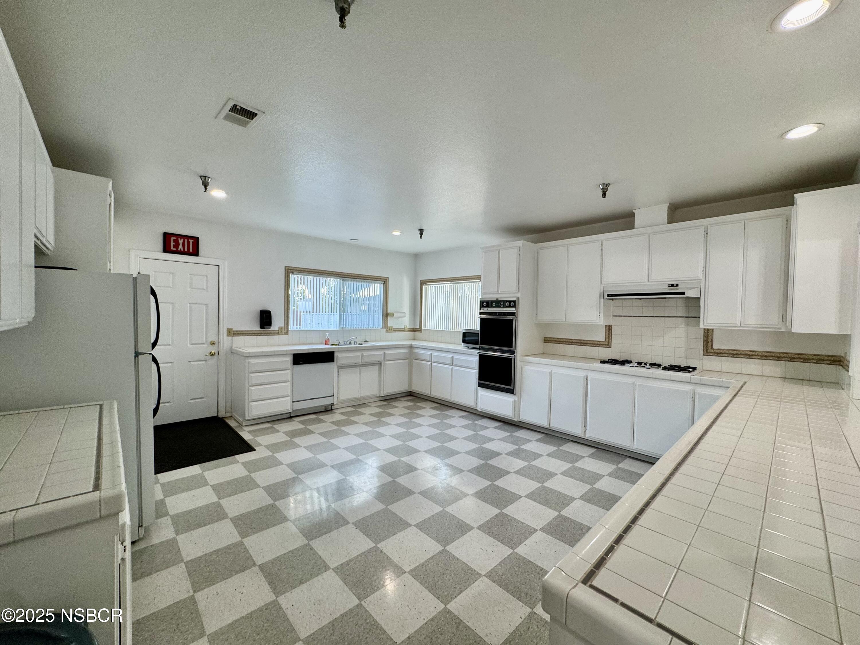 1317 V Street, Unit 58 Lompoc, CA 93436 - Photo 30 of 34 a kitchen with stainless steel appliances a refrigerator sink and microwave