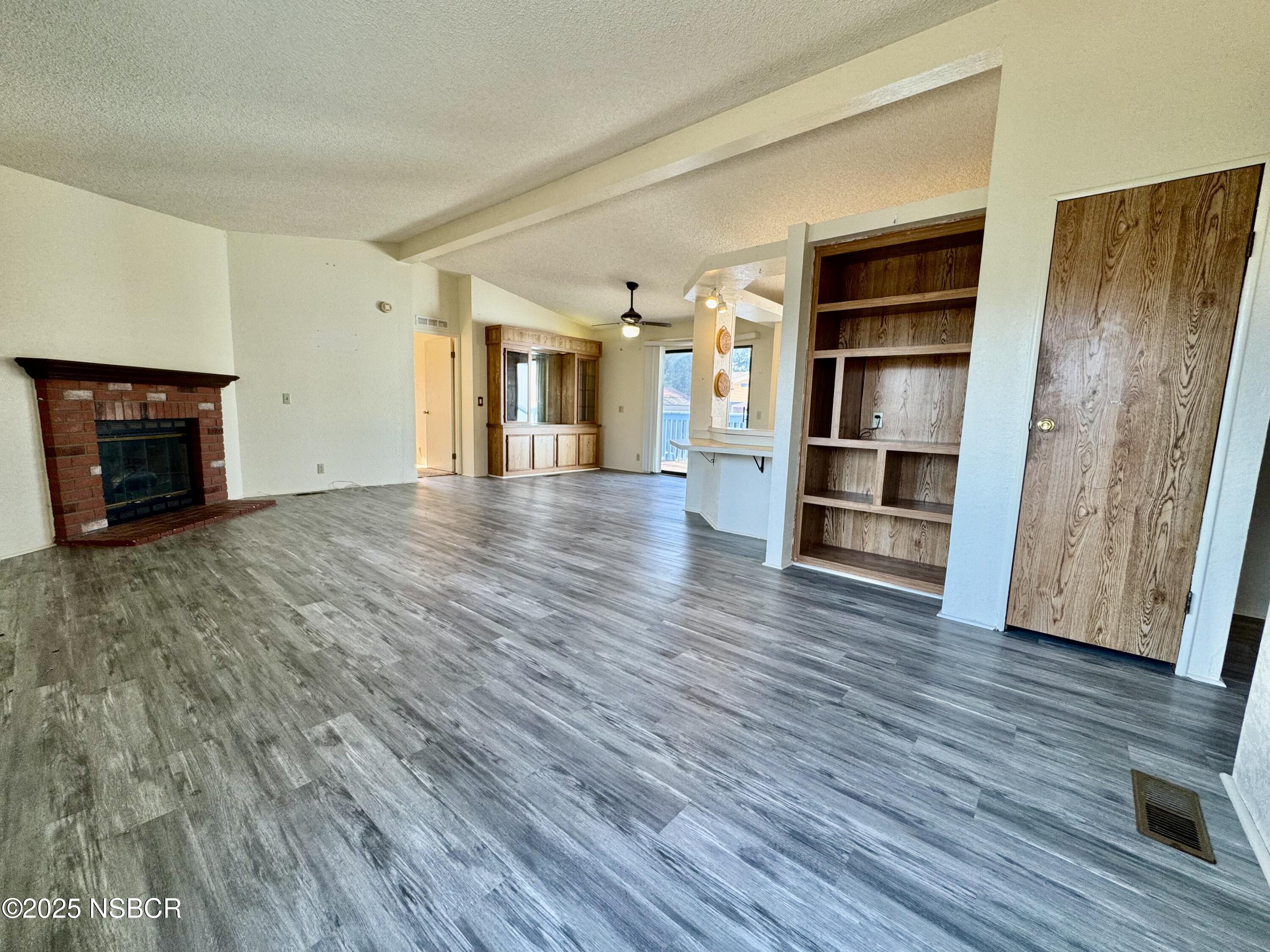 1317 V Street, Unit 58 Lompoc, CA 93436 - Photo 7 of 34 wooden floor in an empty room with a fireplace