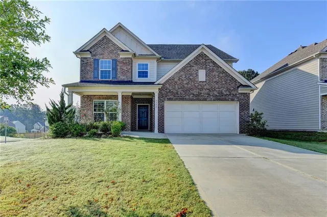 a front view of a house with a yard and garage