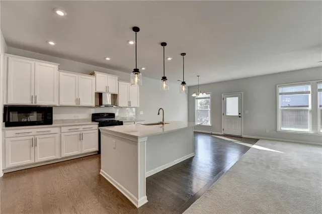 a large kitchen with stainless steel appliances lots of counter space and a sink