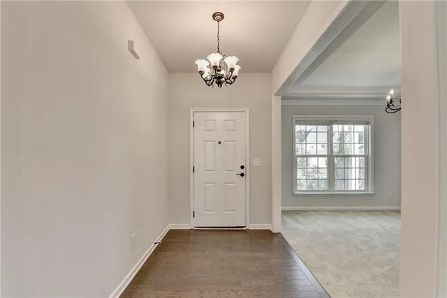 a view of a livingroom with a chandelier fan and windows