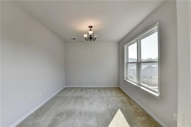 an empty room with a chandelier fan