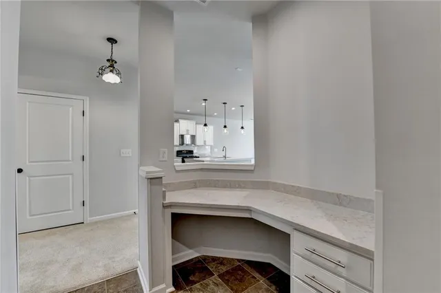a kitchen with kitchen island a white counter top space cabinets and stainless steel appliances