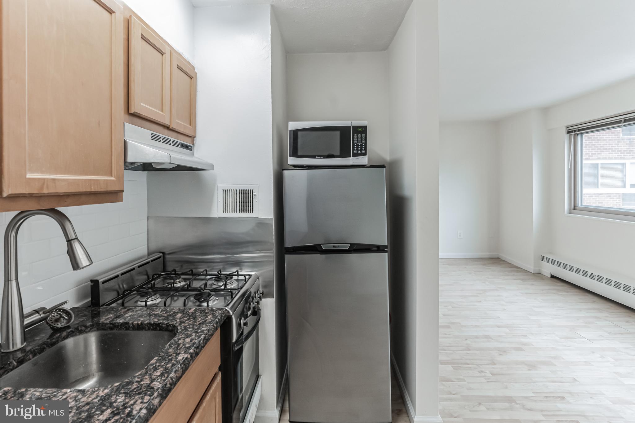 2101 Chestnut Street, Unit 1102 Philadelphia, PA 19103 - Photo 10 of 17 a kitchen with stainless steel appliances granite countertop a refrigerator sink and stove